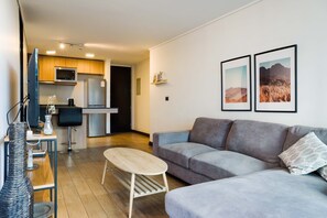 Relax in this stylish living area with a cozy sofa and modern kitchen, perfect for unwinding after exploring the city.