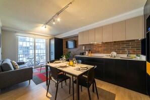 Stylish kitchen and dining area with a cozy sofa and balcony view, perfect for enjoying meals and relaxing.