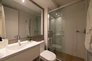 Experience modern elegance in this sleek bathroom, featuring a glass shower and stylish decor.