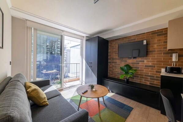 Cozy living room with modern decor and a balcony view, perfect for relaxing after a day of exploring the city.
