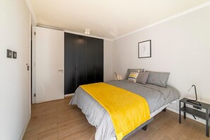Relax in this stylish bedroom with a splash of color, featuring a comfy bed and ample storage space.