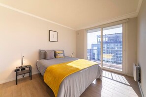 Bright and airy bedroom with balcony access and stylish decor for a relaxing stay.