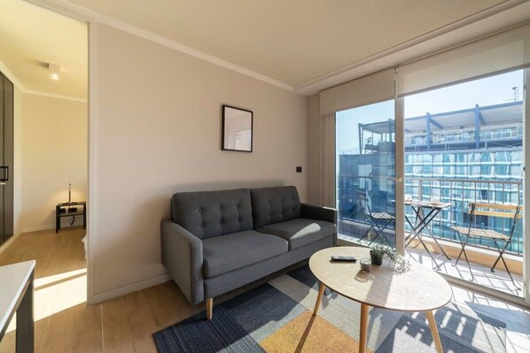 Bright and airy living room with balcony access, perfect for enjoying city views and relaxing in style.