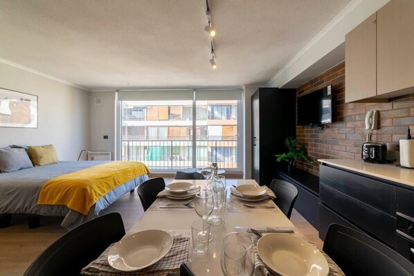 Bright and modern studio with a cozy dining area and large windows for natural light.