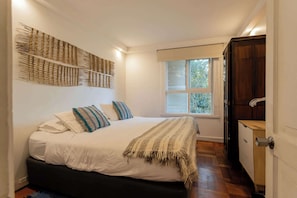 Relax in this cozy bedroom with a plush bed, stylish decor, and a serene view. Perfect for unwinding after a day of exploring.