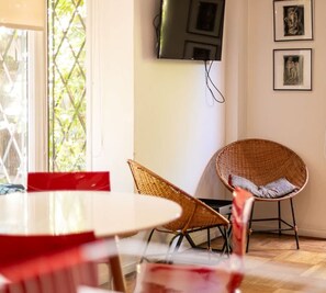 Bright and cozy living area with a stylish dining setup, perfect for enjoying meals with a view of lush greenery.