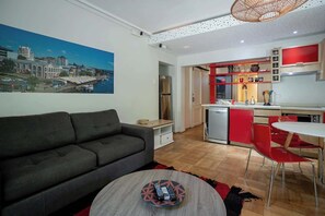 Chic living space with vibrant red accents and modern amenities, perfect for a cozy stay.