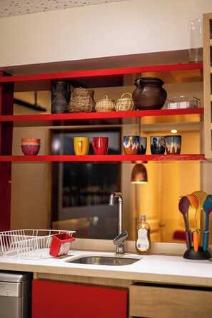 Charming kitchen with vibrant accents and open shelving, perfect for a cozy culinary experience.