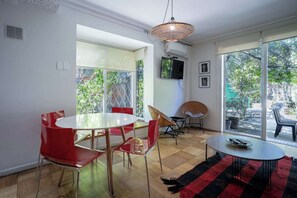 Bright and airy living space with garden views, perfect for relaxing or dining with friends.