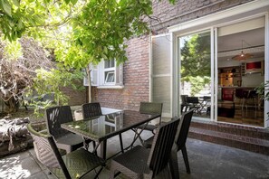 Relax in this serene patio oasis, perfect for al fresco dining amidst lush greenery and easy indoor access.
