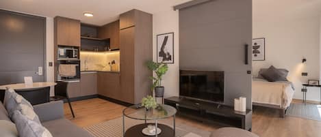 Experience modern comfort in this stylish open-plan living area, complete with a sleek kitchen and cozy bedroom retreat.