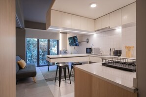 Sleek, modern kitchen with bar seating and natural light, perfect for enjoying a cozy meal or catching up on your favorite shows.
