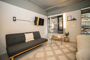Relax in this modern living room with a cozy sofa, stylish decor, and ample natural light, perfect for unwinding after a day of exploring.