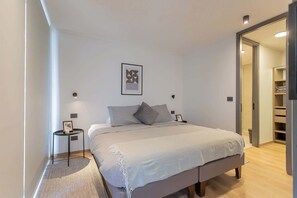 Relax in this cozy bedroom with a king-sized bed, modern decor, and convenient access to the bathroom and closet.