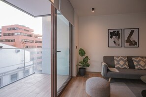 Relax in this modern living room with a cozy sofa and step out onto your private balcony for city views.
