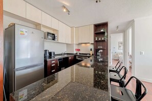 Sleek and modern kitchen with granite countertops and bar seating, perfect for enjoying a cozy meal or morning coffee.