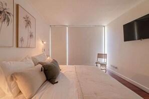 Relax in this cozy bedroom with plush bedding and calming decor, perfect for unwinding after a day exploring the city.