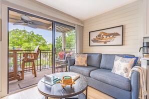 Living room with balcony access and a queen sized sleeper sofa
