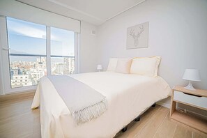 Relax in a cozy bedroom with stunning city views, perfect for unwinding after a day of exploring.
