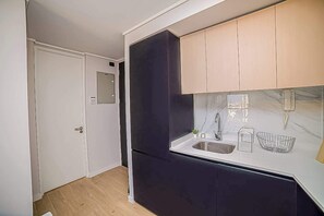 Modern kitchenette with sleek cabinetry and marble accents, perfect for preparing a cozy meal.