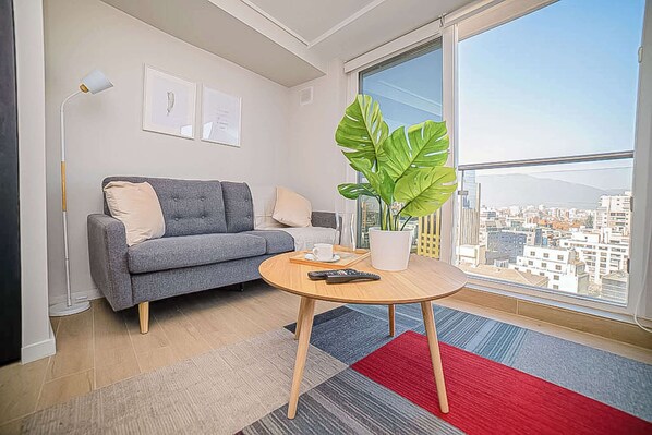 Relax in this stylish living area with stunning city views, perfect for unwinding after a day of exploring.