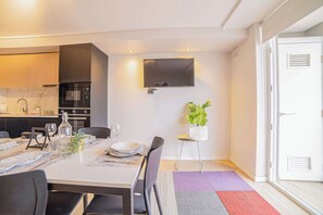 Enjoy a cozy meal in this modern dining area, complete with a sleek kitchen and vibrant decor.