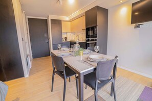 Enjoy a cozy meal in this modern kitchen with sleek appliances and a stylish dining area, perfect for a relaxing stay.