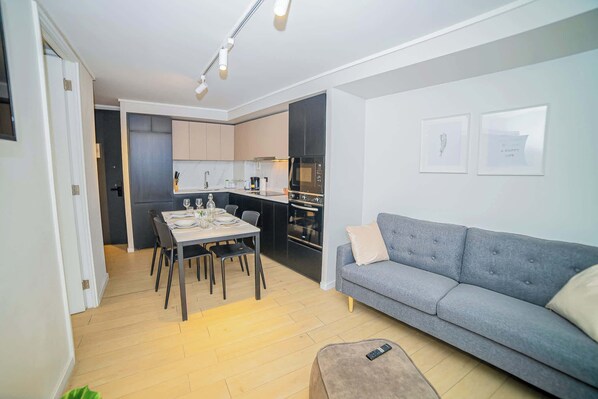 Experience modern living in this stylish studio with a sleek kitchen and cozy lounge area, perfect for a relaxing stay.