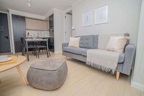 Chic and cozy living space with modern kitchen and dining area, perfect for relaxing or entertaining in the heart of Chile.