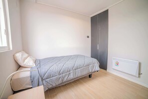 Cozy bedroom with natural light and modern amenities, perfect for a restful stay.