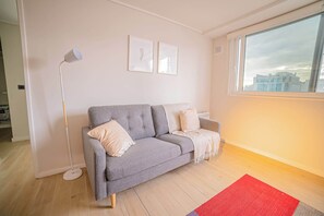 Relax in this cozy living room with a stunning city view, perfect for unwinding after a day of exploring.