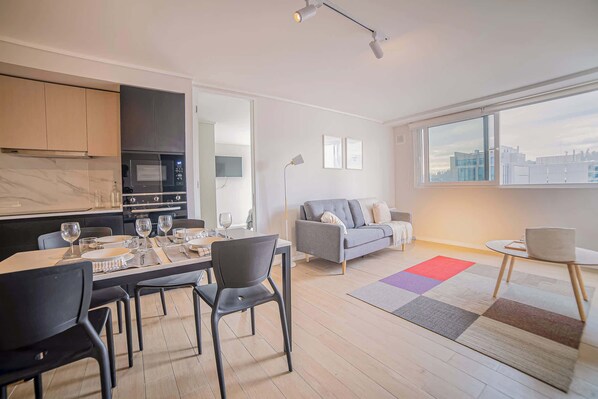 Bright and modern living space with a cozy sofa and dining area, perfect for relaxing after exploring the city.