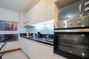 Sleek and modern kitchen with ample natural light, perfect for culinary adventures in the heart of the city.