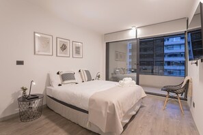 Relax in this chic, modern bedroom with stunning city views and elegant decor.