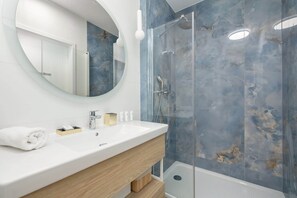 Bright bathroom with washbasin with spacious shower cubicle, decorated in neutral colours for a clean, minimalist look.