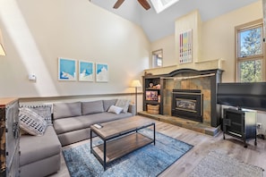 Living room with gas fireplace, sleeper sofa, and deck.