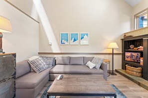 Living room with gas fireplace, sleeper sofa, and deck.