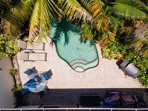 Aerial view of the pool and deck showing the outdoor dining and lounging poolside