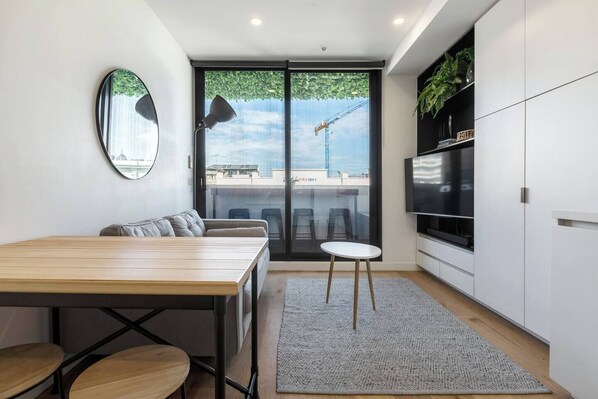 The open plan living area includes a two-seater dining table as well as two small coffee tables.