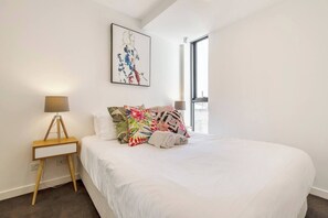 The bedroom features a queen-size bed and a mirrored built-in robe.