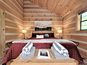 Cozy up in the king size bed at Point of View Cabin, surrounded by rustic charm.
