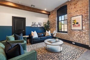 Relax in the living area with a smart TV, stylish seating, and a sleeper sofa for extra guests. Perfect for families or group stays in New Orleans, this inviting space is ideal for movie nights or recharging after a day in the city.