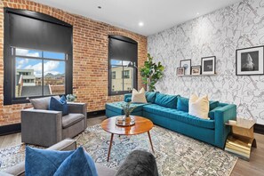 Relax in the living area with a smart TV, stylish seating, and a sleeper sofa for extra guests. Perfect for families or group stays in New Orleans, this inviting space is ideal for movie nights or recharging after a day in the city.