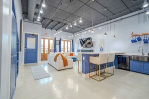 Beautifully decorated living room, with plenty of seating and a designated workspace if you’re traveling for work. 75” Roku TV (must log into your own accounts), fully stocked kitchen with large island and four barstools.