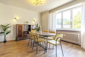 Spacious dining room featuring modern furnishings and elegant lighting. Perfect for hosting family dinners or business meetings in a comfortable setting.