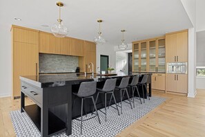 Cooking up some magic in this sleek kitchen with a black island and wooden cabinets!