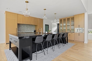 Cooking up some magic in this sleek kitchen with a black island and wooden cabinets!