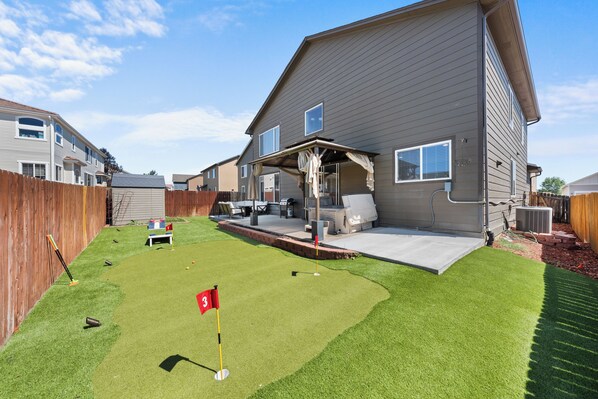 Our beautiful yard with Mini golf course, comfortable seating, grill, firepit and Hot Tub!