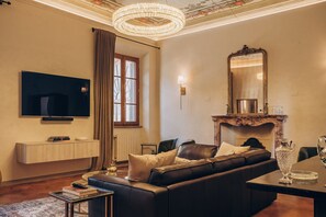 Living Room with comfortable leather couch, 65" TV, and working desk.