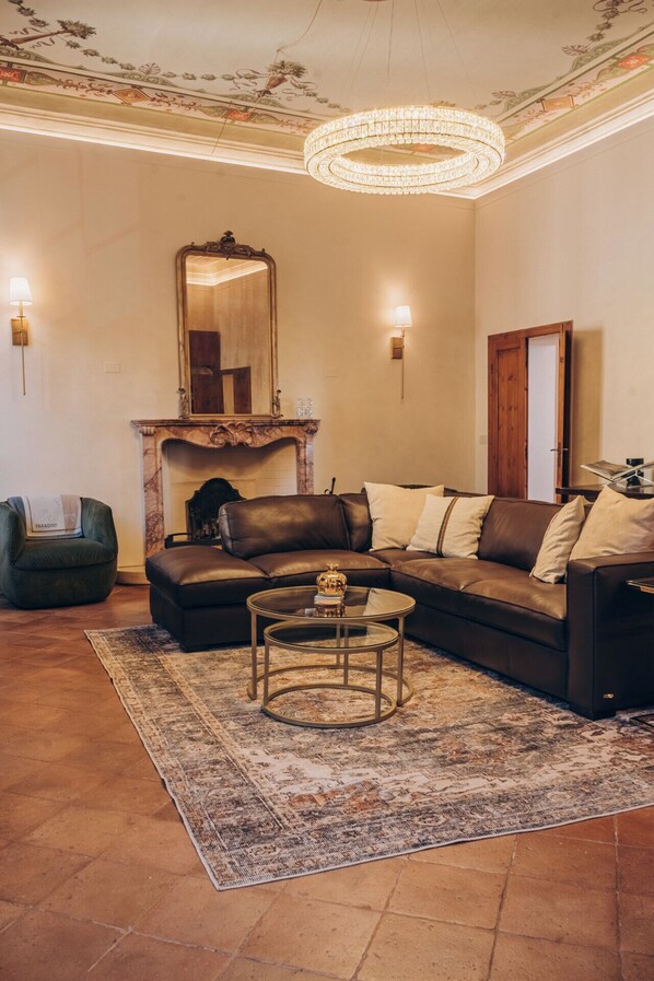 Living Room with comfortable leather couch, 65" TV, and working desk.